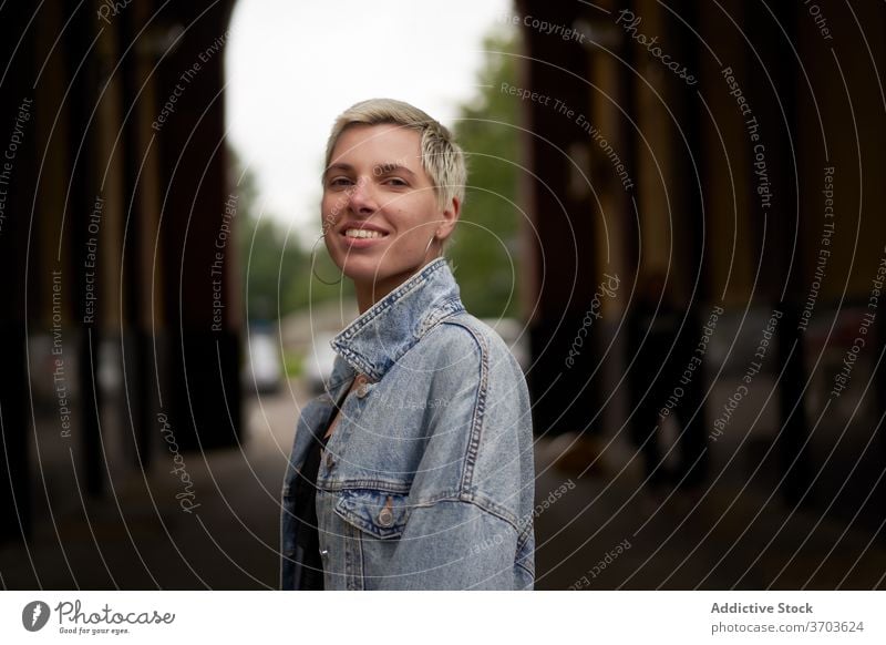 Glückliche stilvolle Frau in der Stadt Model Jeansstoff Jacke Großstadt Straße Windstille Lächeln Stil trendy gewölbt heiter Durchgang lässig besinnlich Outfit