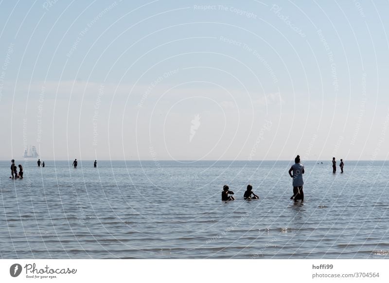 die Menschen erfrischen sich in der auflaufenden Flut -Sommerfrische am Meer sommerfrische Wattenmeer baden seichtes Wasser auflaufendes Wasser Nordsee Horizont