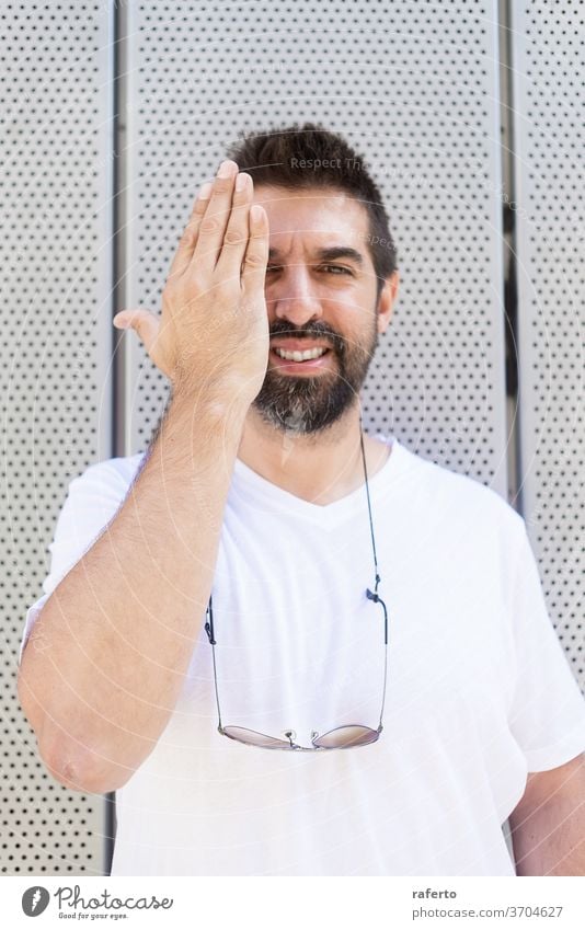 Bärtiger Mann mit Sonnenbrille gestikuliert beim Blick in die Kamera Porträt 1 männlich Person jung Surfer Erwachsener Freizeitkleidung im Freien Wand