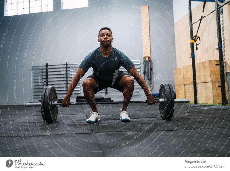 Crossfit-Sportler, der mit einer Langhantel trainiert. Mann Fitness Curl-Hantel Training Übung Muskeln Konzentration Crossfit-Training sportlich Konzept