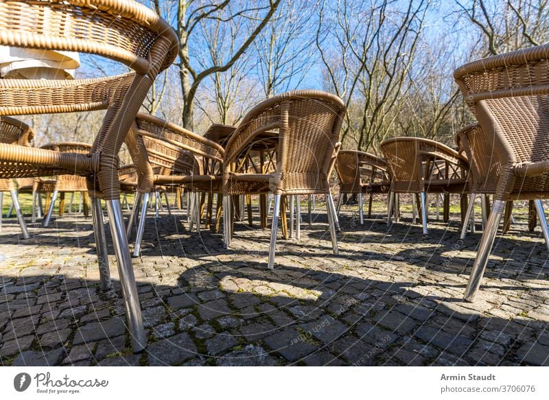 leere Korbstühle eines Cafés auf der Terrasse, draußen Weide Tisch Möbel Restaurant niemand Stuhl im Freien Sitz Straße außerhalb Freizeit Armsessel Rattan