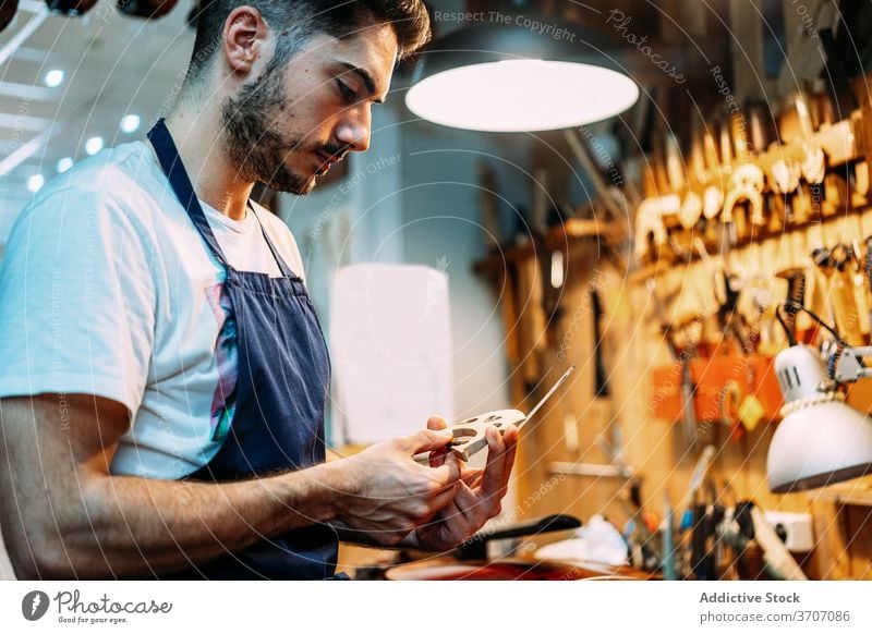 Geigenbauer macht Brücke für Musikinstrument Zupfinstrumentenmacher machen Instrument Reparatur Kunstgewerbler Mann wiederherstellen Handwerk Werkzeug bauen