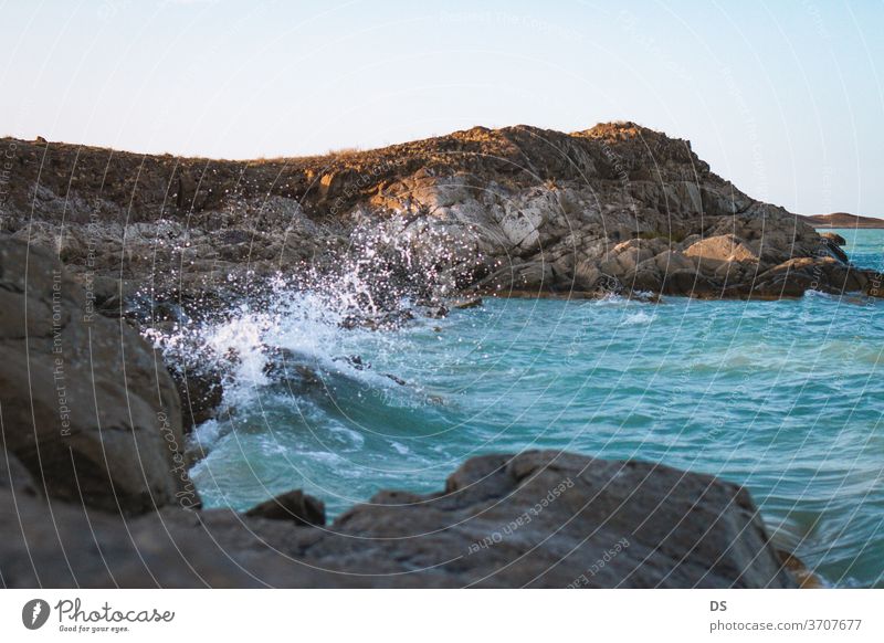 Berge im Meer bei Sonnenuntergang malerisch Ufer Meereslandschaft winken Schönheit Ansicht im Freien Insel Tourismus Hintergrund Stein Strand Küstenlinie Himmel