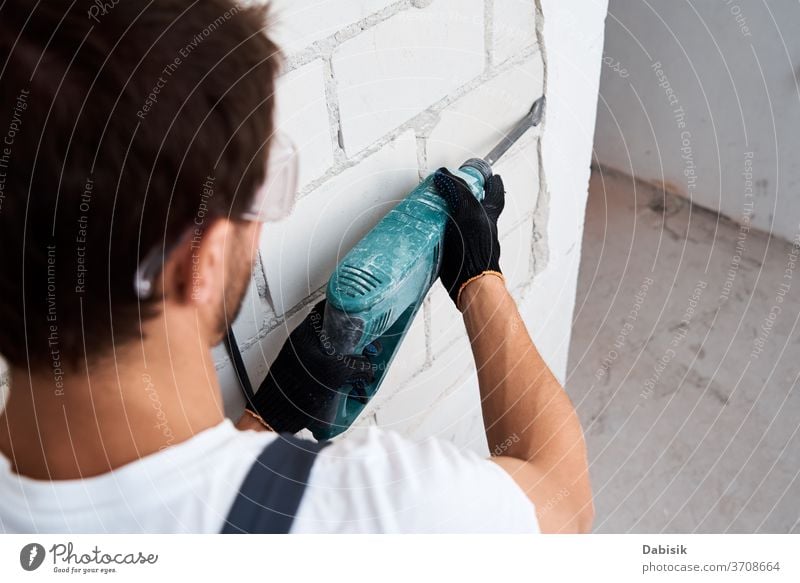 Mann mit Abbruchhammer entfernt Stuck von der Wand. Konzept der Renovierung Abriss Hammer bohren Hand Konstruktion Gerät Arbeit Werkzeug Industrie Maschine