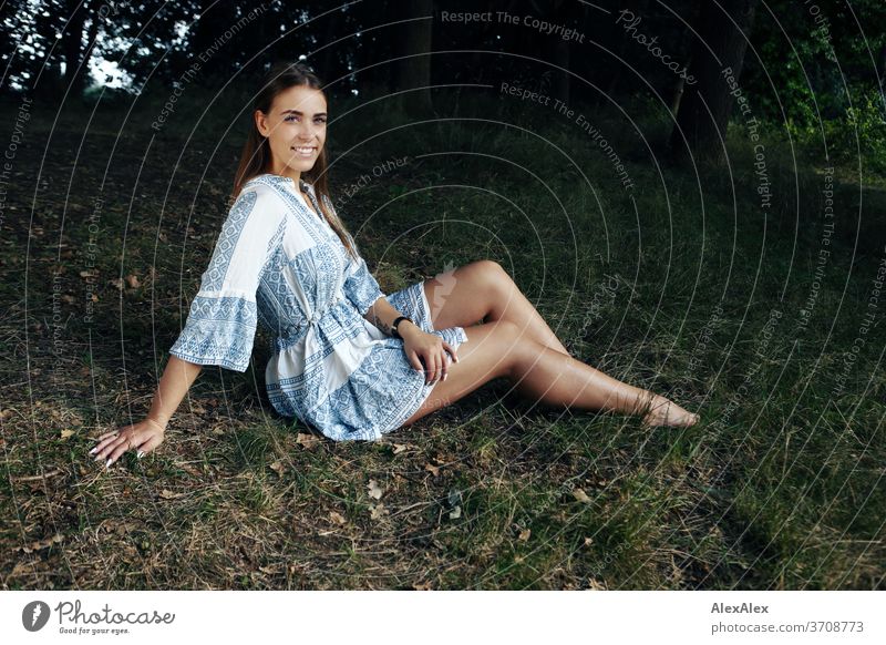 Portrait einer jungen Frau in weiß- blau gemustertem Sommerkleid in der Natur Licht sportlich feminin Gefühle emotional Blick in die Kamera Porträt