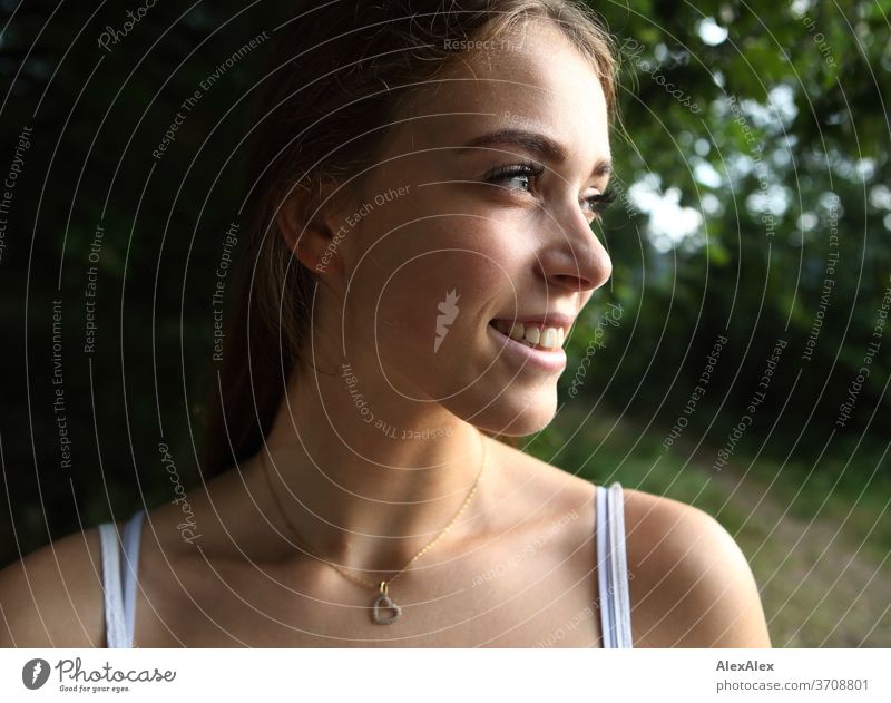 Seitliches, nahes Portrait einer jungen Frau in der Natur Licht sportlich feminin Gefühle emotional Blick in die Kamera Porträt Zentralperspektive