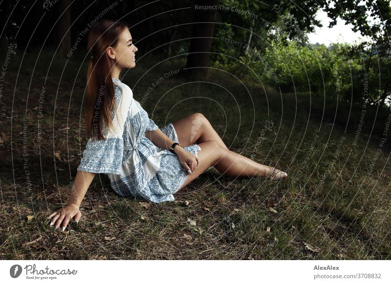 Portrait einer jungen Frau in weiß- blau gemustertem Sommerkleid in der Natur Licht sportlich feminin Gefühle emotional Porträt Zentralperspektive