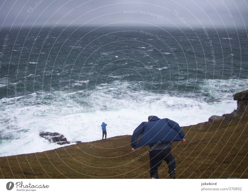 Kampf gegen Naturgewalten Mensch maskulin Sturm Wellen Küste Meer Klippe Hose Jacke Kapuze standhaft Atlantik Horizont Gischt Brandung Regenjacke Gegenwind