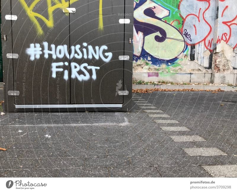 Graffiti mit Hashtag: #HousingFirst / Foto: Alexander Hauk kunst tageslicht außenaufnahmen boden pflastersteine querformat housing housingfirst hashtag