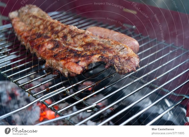 Über den Kohlen gegrillte Schweinerippchen. Begriff des Essens. Raum kopieren. Holzkohle Rippen Schweinefleisch Braten Feuer Glut Gewürz Feier Restaurant