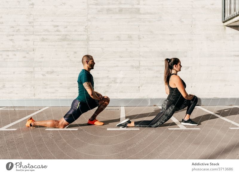 Sportliches Paar beim Aufwärmen vor dem Training Dehnung Körper Zusammensein Athlet beweglich Sportbekleidung Gesundheit Aktivität Wohlbefinden stehen