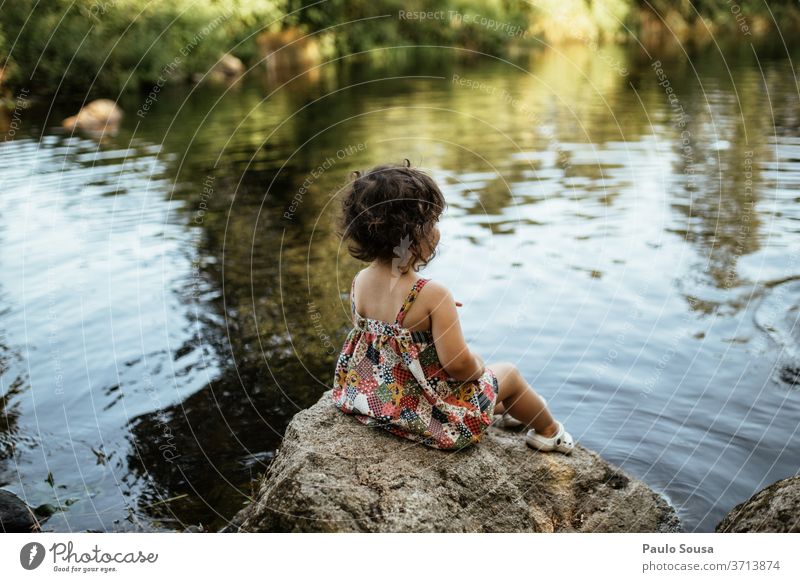 Kind am Flussufer sitzend Kindheit Kindheitserinnerung Mensch Sommer Freude Freizeit & Hobby Farbfoto Kleinkind Spielen Außenaufnahme reisen Lifestyle