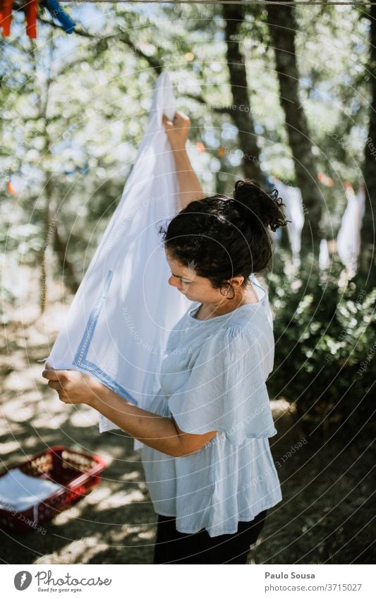 Frau hängt Kleidung an Wäscheleine Bekleidung Kleiderhaken heimisch häusliches Leben Hausfrau Hausarbeit Haushaltsführung aufhängen Waschtag Farbfoto Sauberkeit