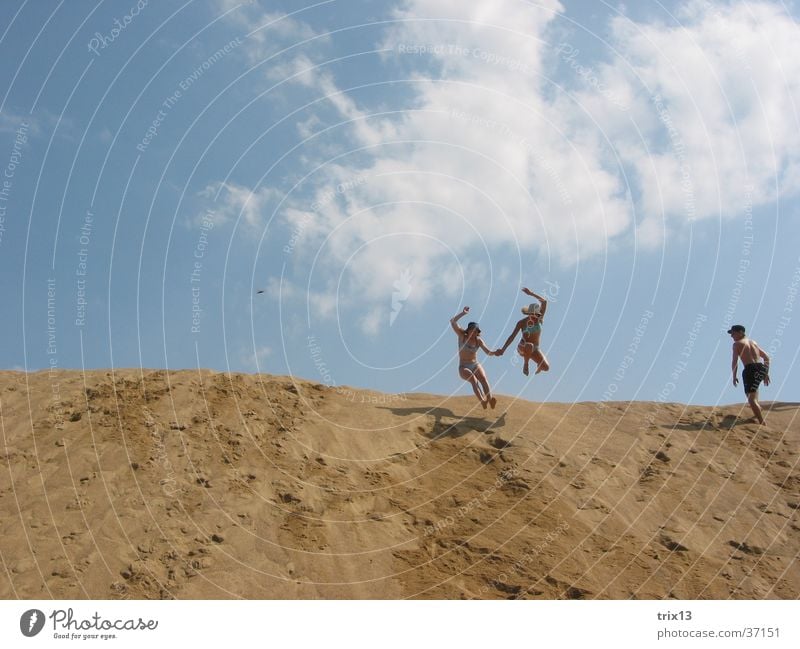 Sandsprung_2 Hand in Hand springen Hügel Wolken Mensch hoch höhe Ferne Himmel blau