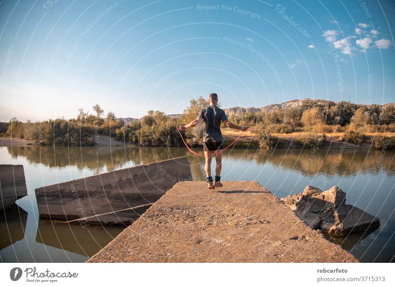 Mann trainiert neben dem Fluss männlich sportlich Sport Jogger Brücke Gesundheit Training im Freien Lifestyle aktiv Athlet Himmel Läufer arbeiten Männer Fitness