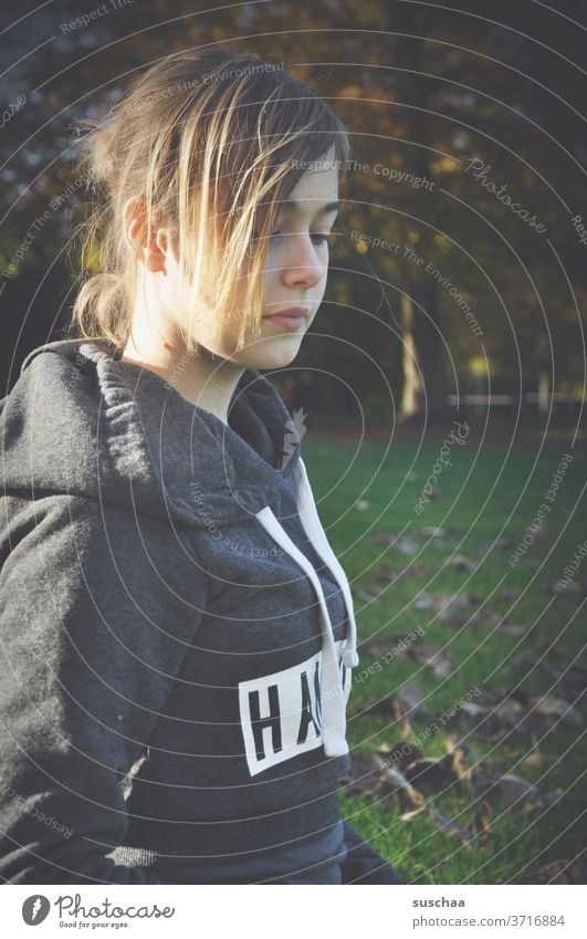 jugendliche mit haaren im gesicht in einem herbstlichen park Jugendliche Teenager Mädchen Haare Park draußen Herbst Natur Jahreszeit Baum Gras Blätter Laub