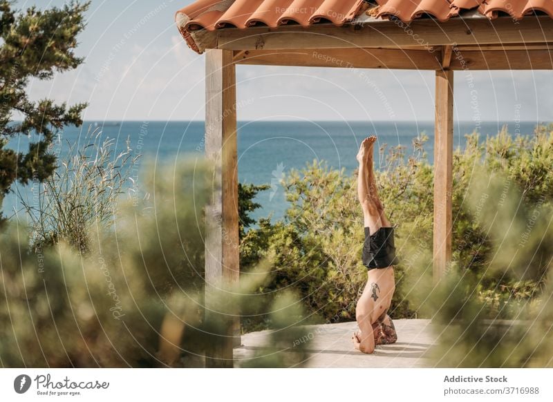 Starker Sportler beim intensiven Training calisthenics Übung Handstand Mann Gleichgewicht muskulös stark männlich Körper Fitness Kraft Athlet Gesundheit