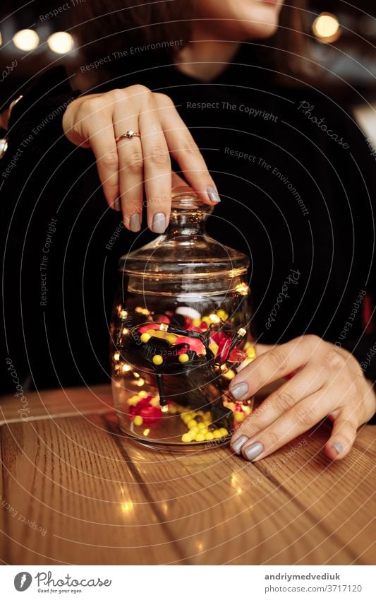 junge Frau zeigt Flasche mit Medikament. farbige Kapseln. Verschiedene medizinische Kapseln, die aus einem Glas ausgelaufen sind. medizinisches Konzept Medizin