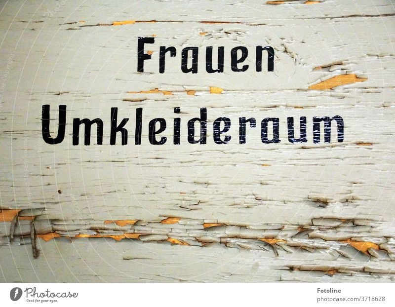 Frauen Umkleideraum steht an einer alten verfallenen Holztür, an der bereits die Farbe abblättert. Schrift Buchstaben Schriftzeichen Wort Text Typographie