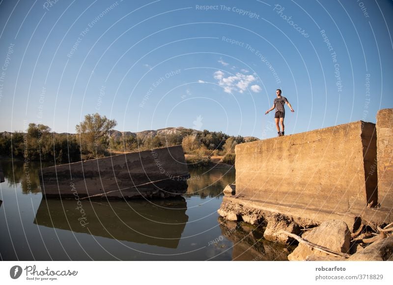 Mann trainiert neben dem Fluss männlich sportlich Sport Jogger Brücke Gesundheit Training im Freien Lifestyle aktiv Athlet Himmel Läufer arbeiten Männer Fitness