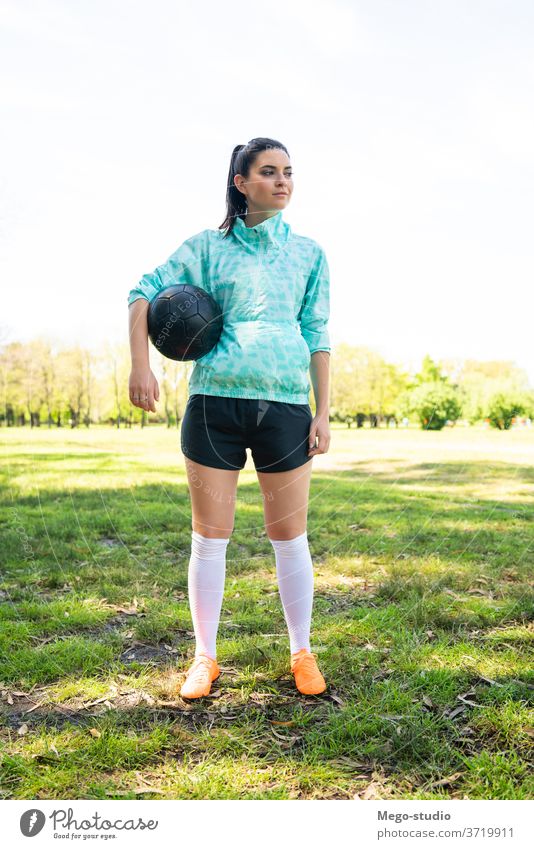 Junge Fußballspielerin steht auf dem Spielfeld und hält den Ball. jung Frau Spieler Tatkraft Vorbereitung Sportlerin Fußballer praktizieren Athletik fokussiert