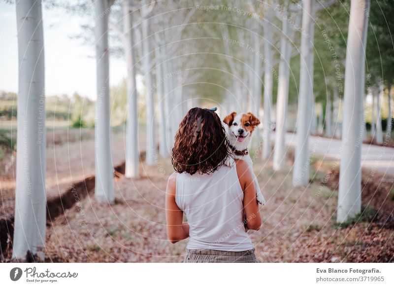 junge glückliche Frau in einem Auto, die ihren süßen Hund kuschelt. Reisekonzept Sonnenuntergang im Freien Liebe Zusammensein Park jack russell Lifestyle