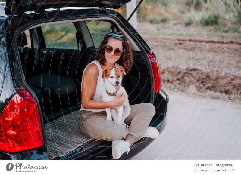 junge glückliche Frau in einem Auto, die sich mit ihrem süßen Hund vergnügt. Reisekonzept PKW reisen jack russell Zusammensein Liebe im Freien Lifestyle