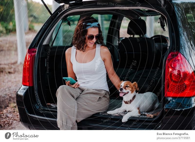 junge glückliche Frau in einem Auto, die sich mit ihrem süßen Hund vergnügt. Reisekonzept PKW reisen jack russell Zusammensein Liebe im Freien Lifestyle