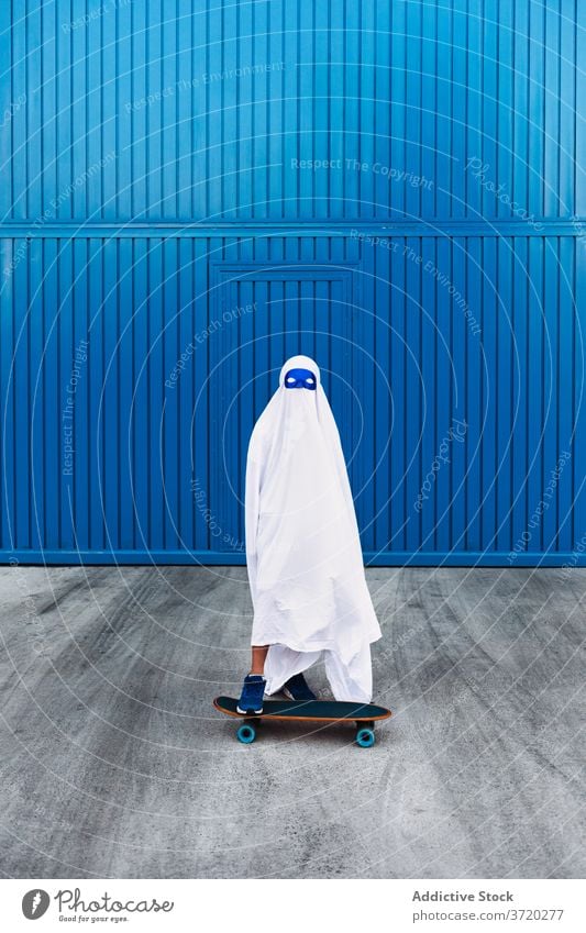 Kind im Geisterkostüm auf der Straße Tracht Halloween Feiertag Skateboard Skater gruselig Veranstaltung Herbst beängstigend unterhalten spukhaft feiern Saison