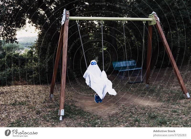 Kind im Geisterkostüm im Hof Tracht Halloween spielen Anzug Spielplatz Feiertag Herbst Spaß haben Veranstaltung beängstigend unterhalten spukhaft feiern Saison