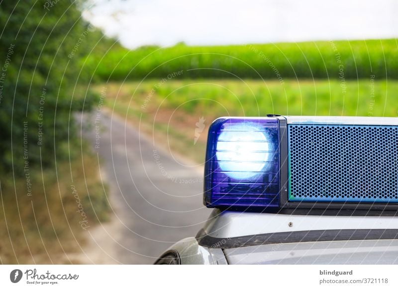 Die Fahndung nach dem Freitag hat begonnen Polizei Blaulicht Polizeiwagen Einsatz Notfall Sirene Martinshorn Außenaufnahme Baum Straße Feld KFZ Verkehr