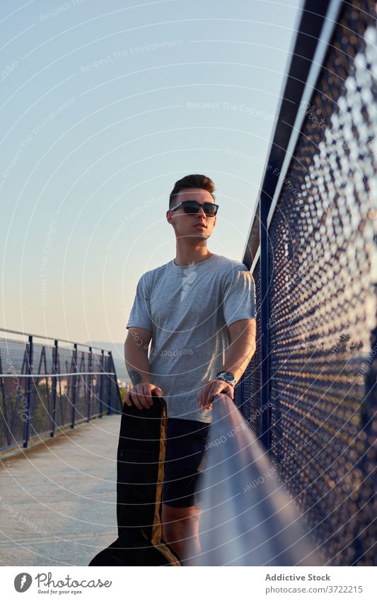 Seriöser Mann mit Gitarre in der Stadt Musiker Gitarrenspieler Großstadt Brücke Windstille ernst Talent Spieler männlich Fall selbstbewusst gutaussehend