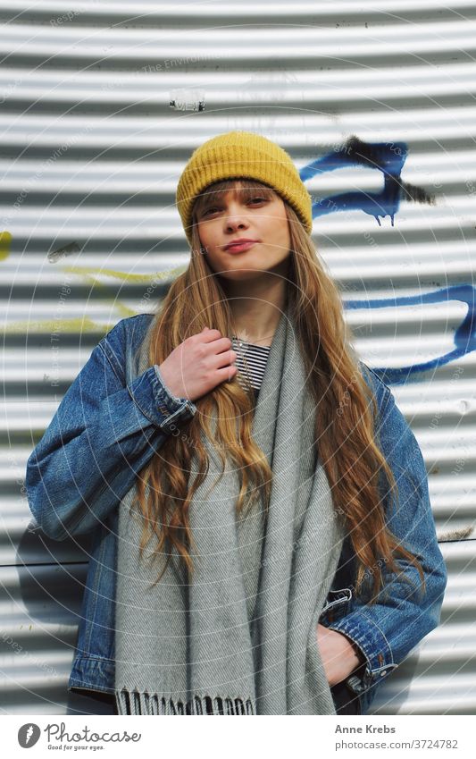 Portrait einer jungen Frau Mädchen Street lange Haare Mütze gelb blau blond Cool schön attraktiv Model hübsch Mensch streetstyle Streetlife Jeansjacke frontal