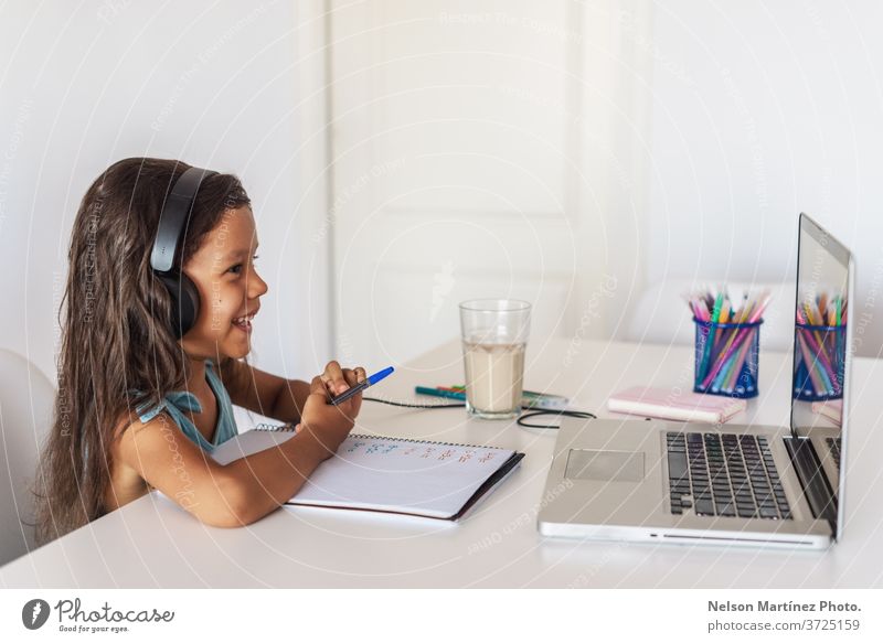 Kleines hispanisches Mädchen, das vor dem Laptop lernt. E-learning, zu Hause online lernen. Computer Kinder jung Video Schule Bildung E-Learning Lernen