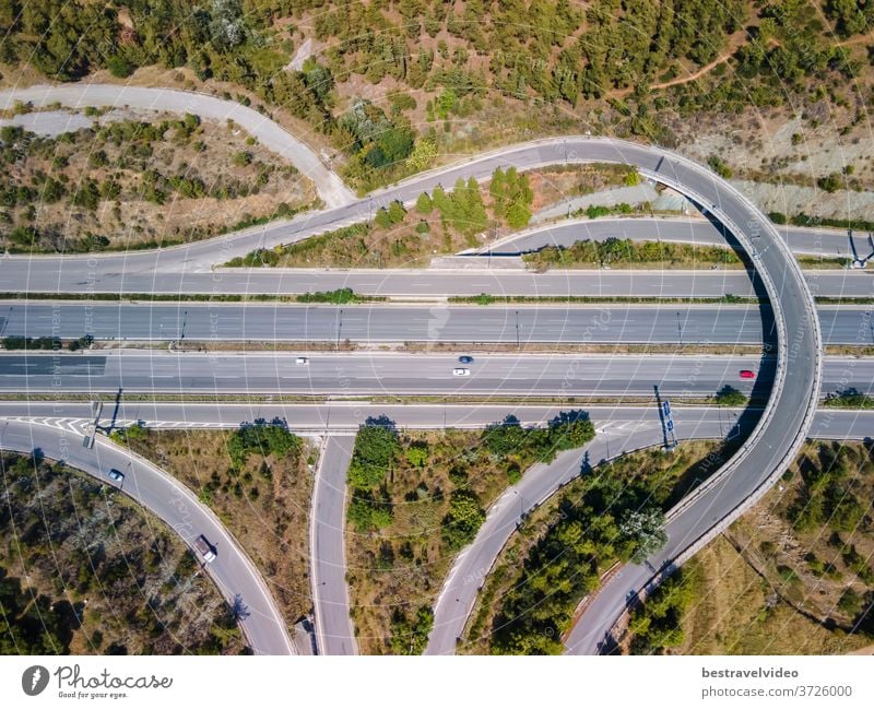 Thessaloniki, Griechenland: Drohnenlandschaft des Kreuzungsverkehrs auf der inneren Ringstraße Periferiaki. Tagesspitzenpanorama eines europäischen Mehrebenen-Stapelautobahnkreuzes mit vorbeifahrenden Autos durch Wald.