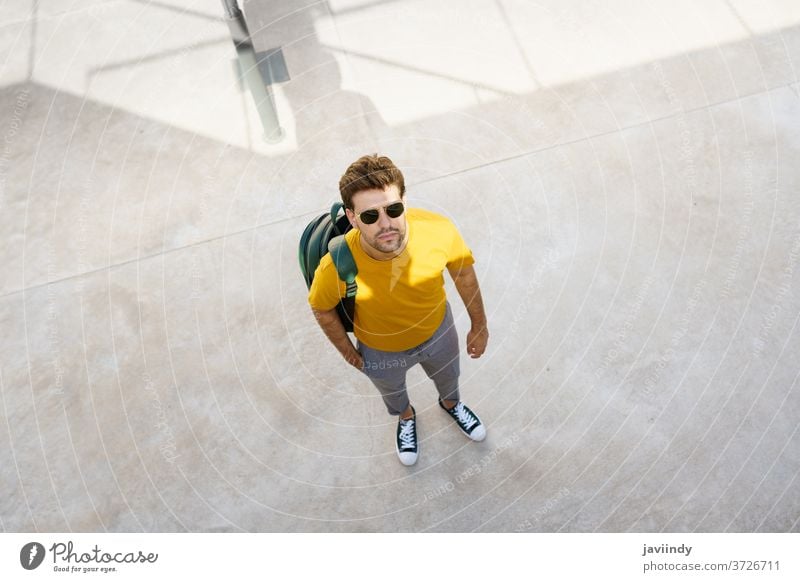 Draufsicht auf einen männlichen Studenten auf dem Universitätscampus. Mann urban Schüler jung Rucksack Lifestyle Stil Person Kaukasier Typ lässig Straße