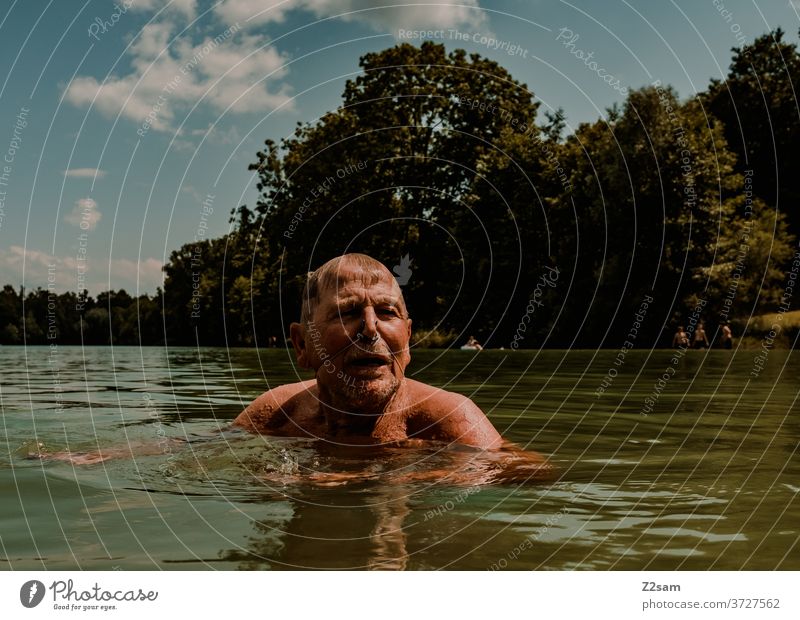 Rentner beim Schwimmen im See schwimmen freizeit rentner rente sommer see gewässer wasser sport bewegung nasenklammer sportlich braun alter mann portrait