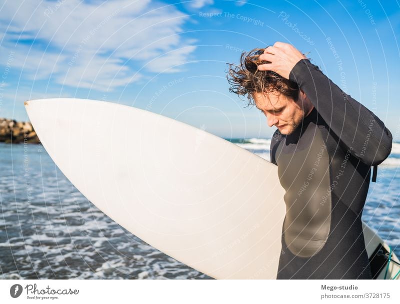 Surfer, der mit seinem Surfbrett im Meer steht. Mann Brandung Wasser Sport Surfen MEER im Freien sportlich Küstenlinie Wellen Hintergrund Abenteuer