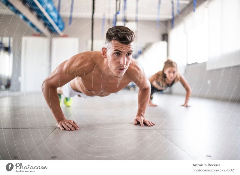 Paartraining schiebt sich hoch trainiert. Fitnessstudio Mann hochschieben Sport Menschen Fitnesstraining Stärke Frau Athlet Errungenschaft Motivation Training