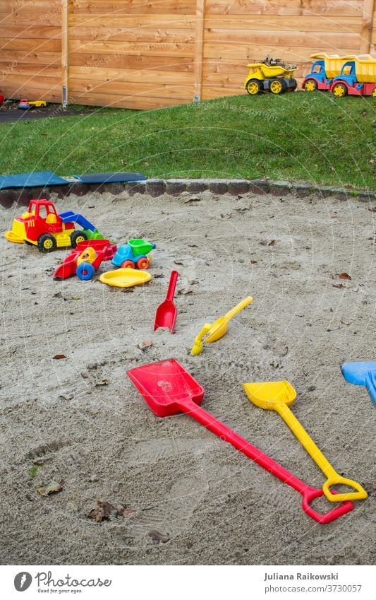 Spielzeug im Sandkasten Spielen Außenaufnahme Farbfoto Kind Freude Kindheit Kindergarten Tag Kleinkind Kinderspiel Freizeit & Hobby Kindererziehung Spielplatz