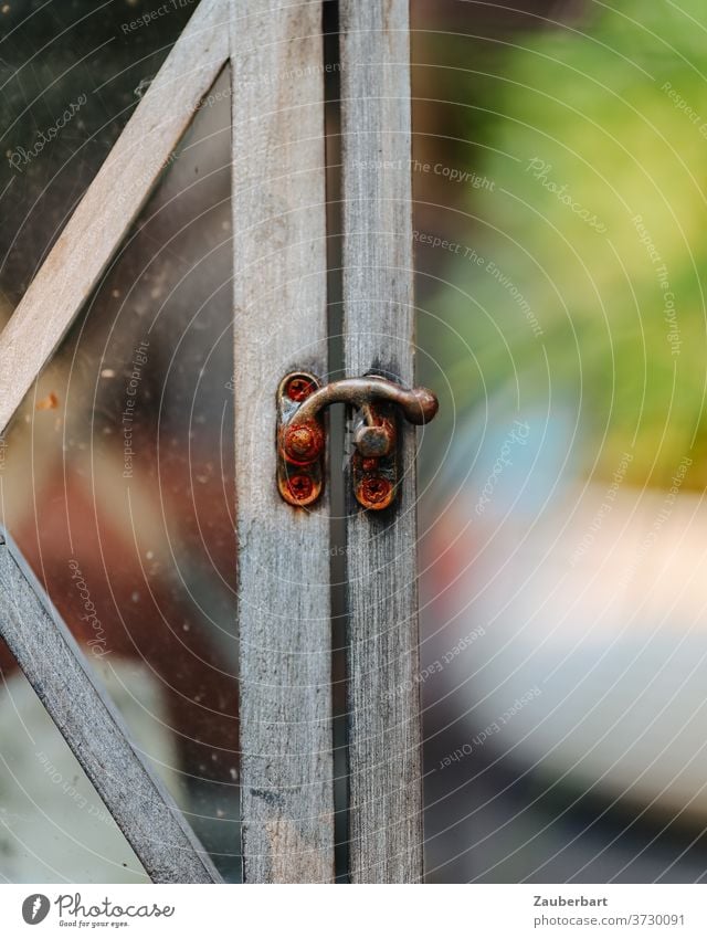 Kleiner Türriegel der Holztür einer Laterne Riegel Teakholz Windlicht Garten Terrasse Detail Rost Hebel Beschlag Schrauben Licht Schloss Detailaufnahme Metall