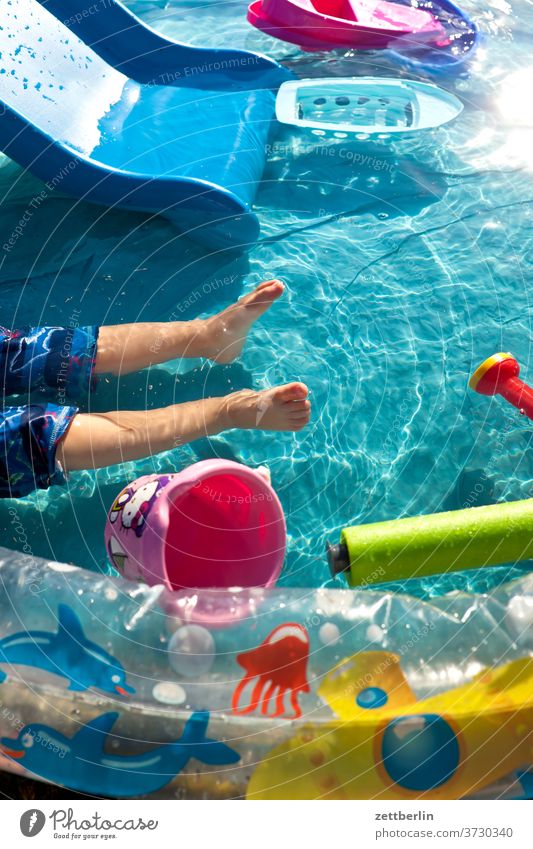 Kleinkind im Planschbecken kleinkind wasseroberfläche schiffchen gießkanne eimer spiel spielzeug wasserspielzeug hitze hochsommer baden wasserbecken