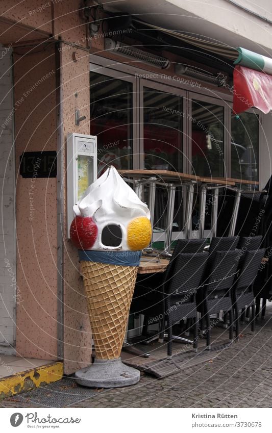 abfall-eistüte mit offenem mund mülleimer abfalleimer eiswaffel aufgerissen erstaunt verzweifelt ängstlich eisdiele eiscafé pareidolie gesicht tische stühle