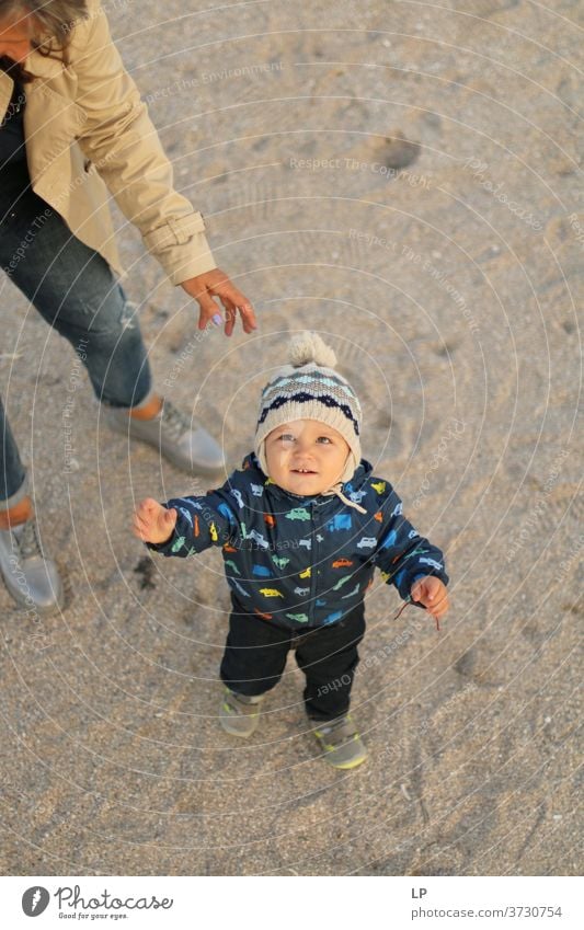 kleines Baby, das unter dem Schutz eines Erwachsenen in den Himmel schaut Porträt Mutterliebe Geborgenheit Sicherheit Freitreppe Wachstum Helfer hilflos