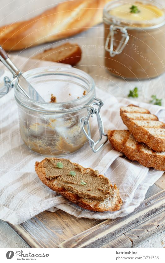 Sandwiches mit hausgemachter Pastete Baguette pate abschließen Zuprosten Kraut Glas hölzern selbstgemacht Leber rustikal Mousse Thymian Hausgans Tisch geröstet