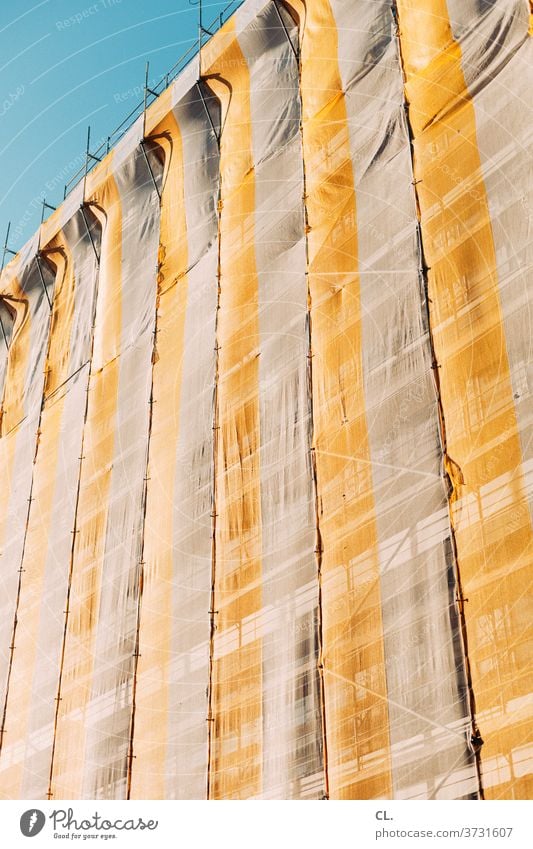 gerüstnetz Gerüst Gerüstnetz Gerüstplane Baustelle Baugerüst Himmel gelb Blauer Himmel hoch Abdeckung Wandel & Veränderung Haus Gebäude Fassade Sanieren Schutz