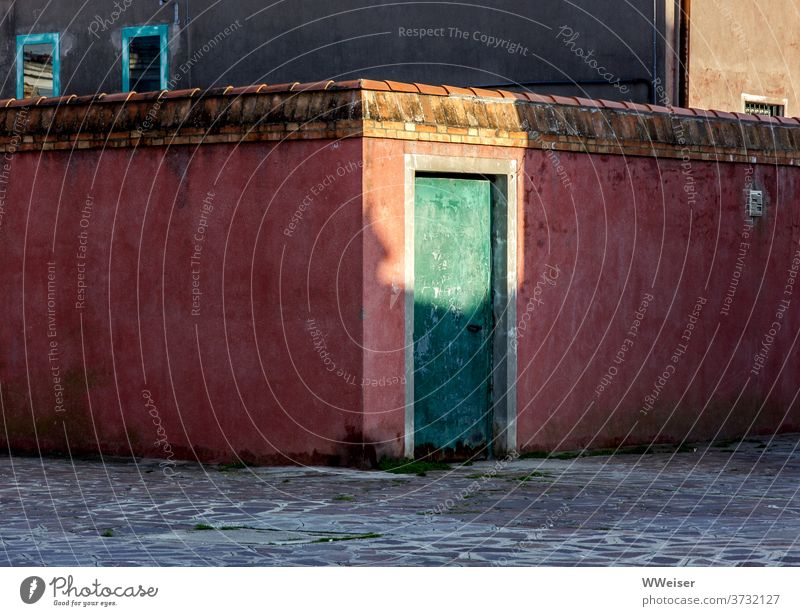 Abendlicht beleuchtet eine alte rote Mauer mit einer grünen Tür Licht Dämmerung Sonnenlicht Sommerabend warm Wand historisch Venedig verschlossen still ruhig