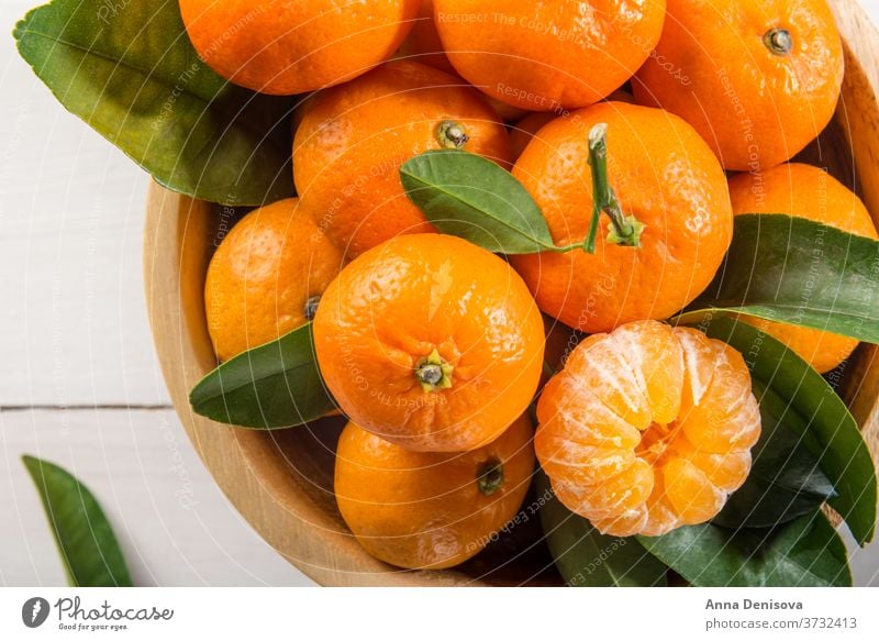 Köstliche und schöne Mini-Mandarinen orange Clementine Zitrusfrüchte Nahaufnahme reif grün Gesundheit frisch süß Frucht organisch saftig Natur weiß hölzern