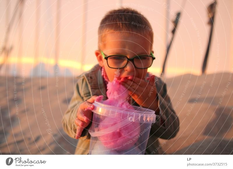 Kind isst Zuckerwatte Moment Fröhlichkeit Kindheitstraum Kindheitserinnerung Kinderspiel Brille positive Emotion Humor urkomisch lustig," Wahrheit Überraschung