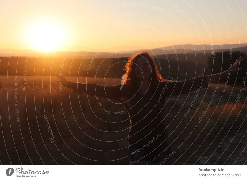 Frau mit offenen Armen vor roter Landschaft mit Sonnenuntergang Lebensglück glücklich Fröhlichkeit Glück Lebensfreude Freude Zufriedenheit Mensch